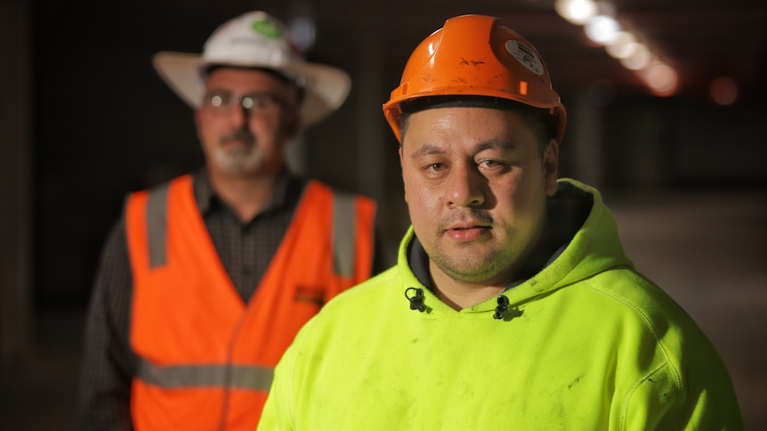 Two men on a construction site wearing high-vis