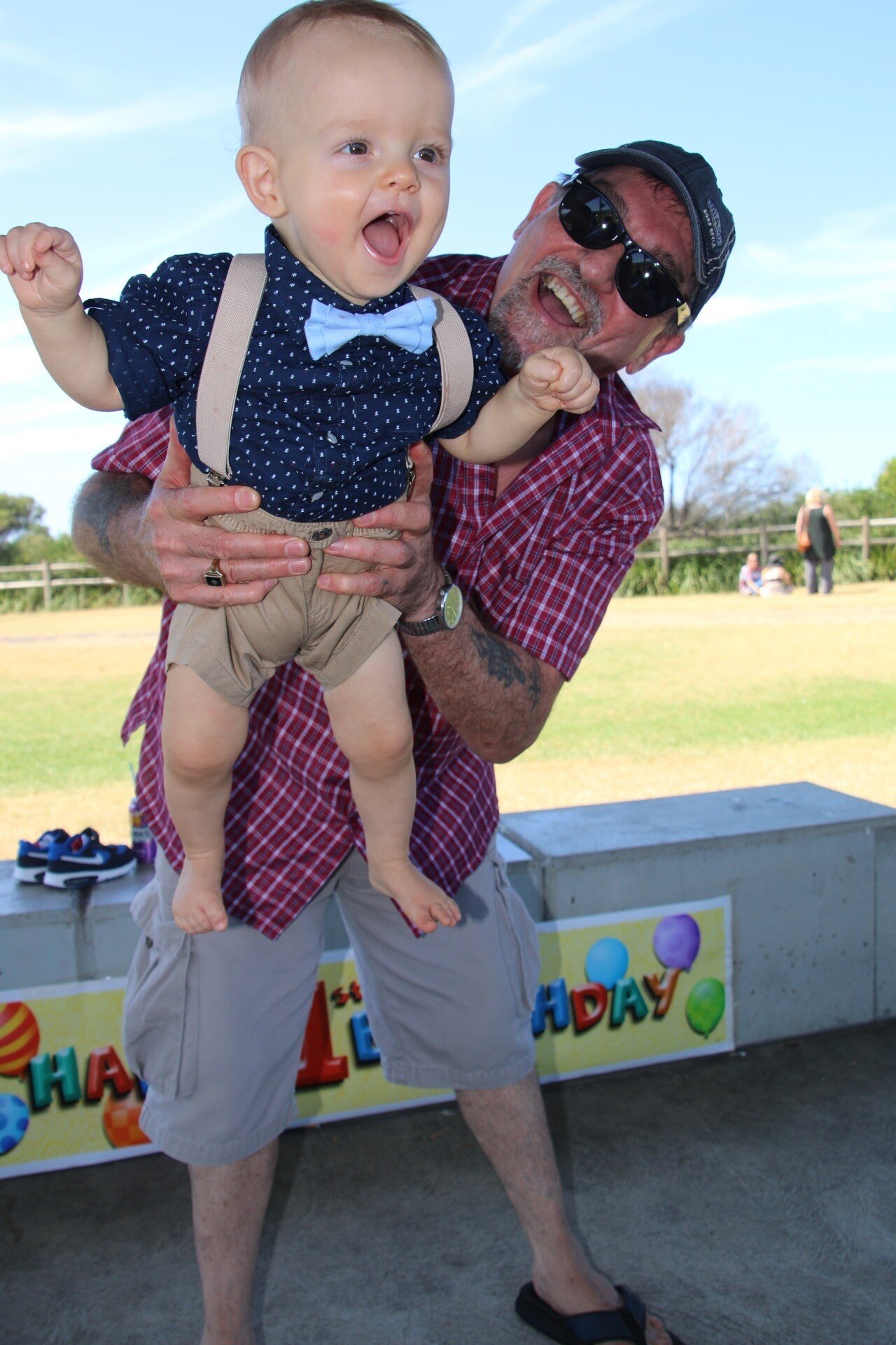 সবুজ ক্ষেত্রের সামনে একজন বয়স্ক ব্যক্তির দ্বারা স্যুটটিতে শিশুর চিত্র