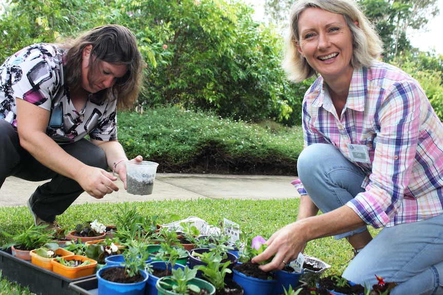 Volunteer Allira and horticultural therapist Cath Manuel put the finishing touches on the seedlings.