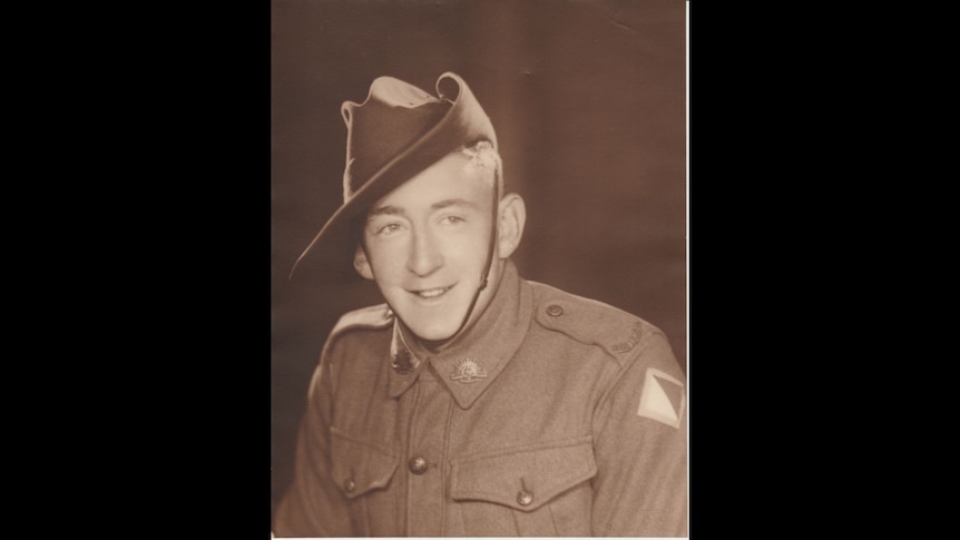 A sepia photo of a young smiling man in army uniform