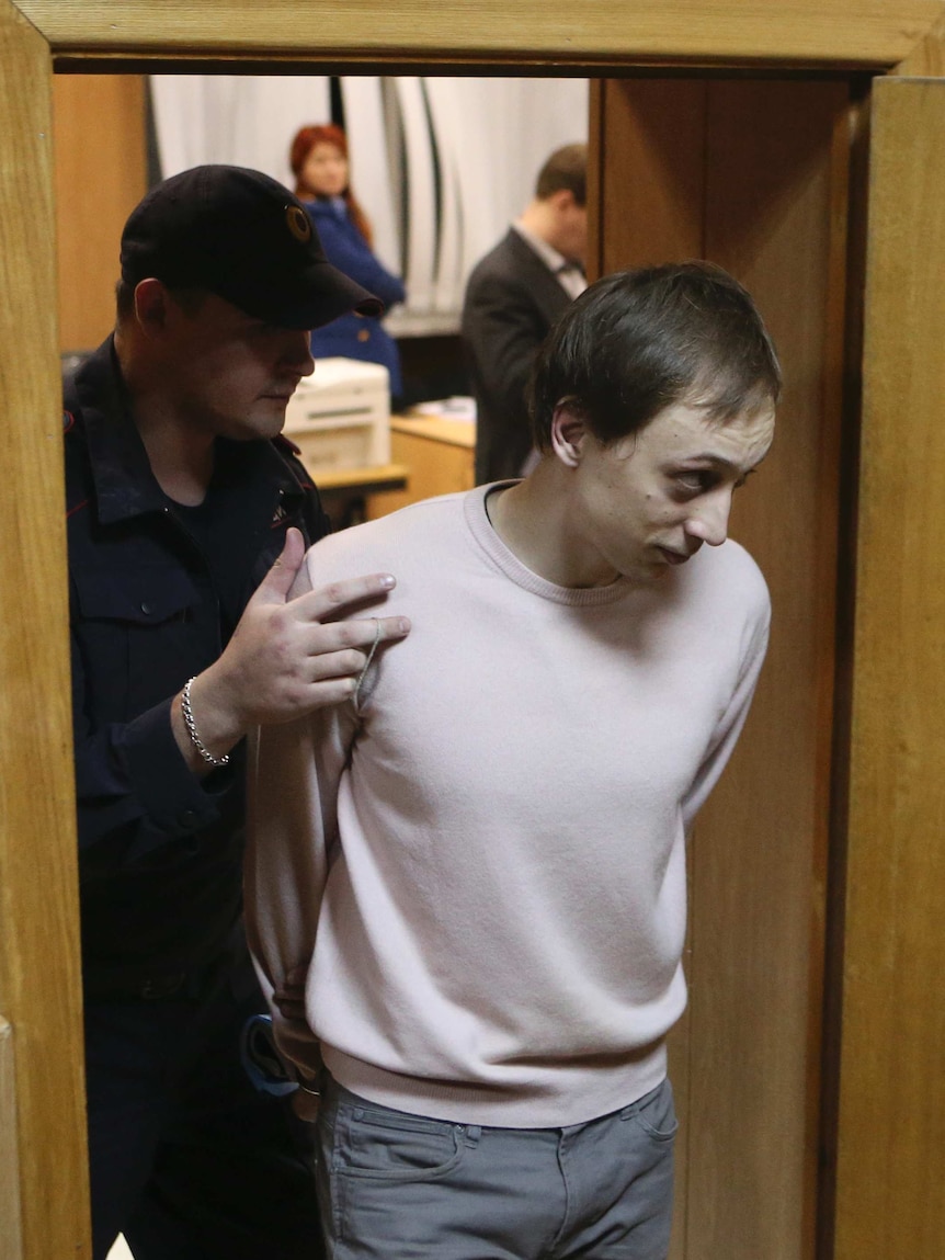 Bolshoi Theatre dancer Pavel Dmitrichenko being led out of court
