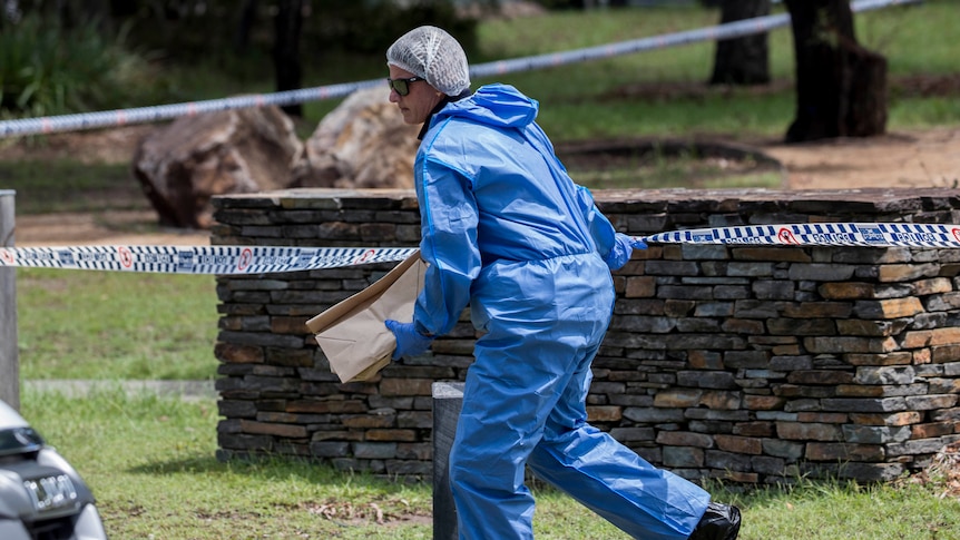 A forensic officer with a brown bag.