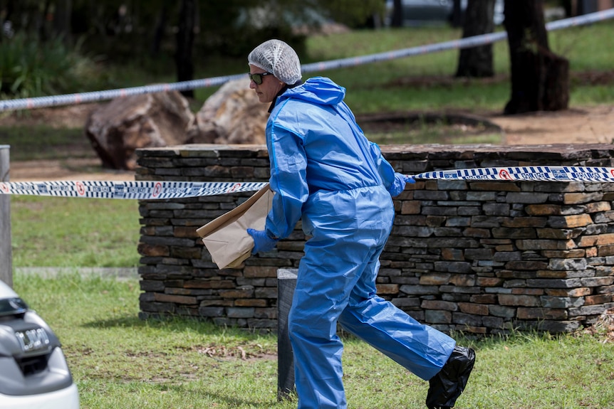 A forensic officer with a brown bag.