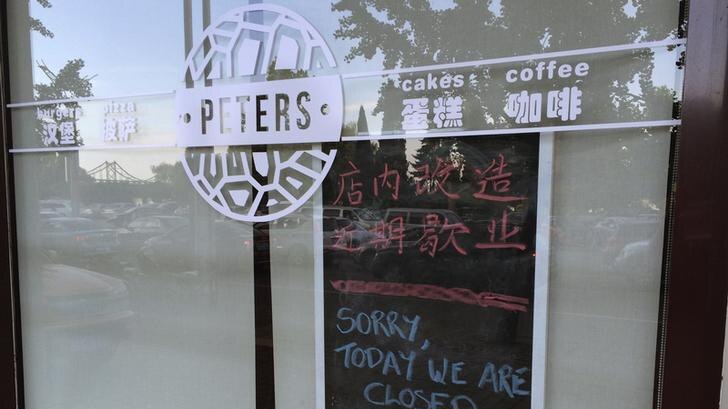 Julia and Kevin Garratt owned coffee shop in China with sorry we are closed sign