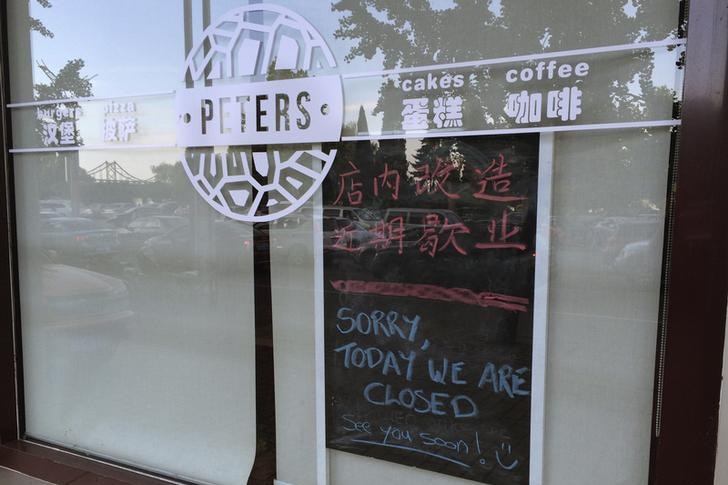 Julia and Kevin Garratt owned coffee shop in China with sorry we are closed sign