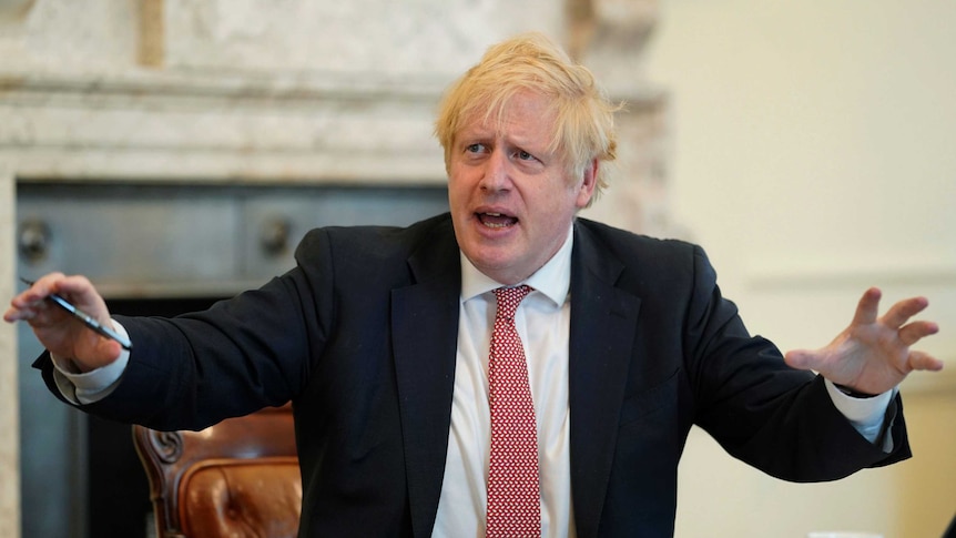 Boris Johnson gestures outwardly with his hands