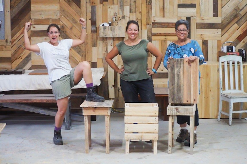 Mother and her two daughters finish making tables.