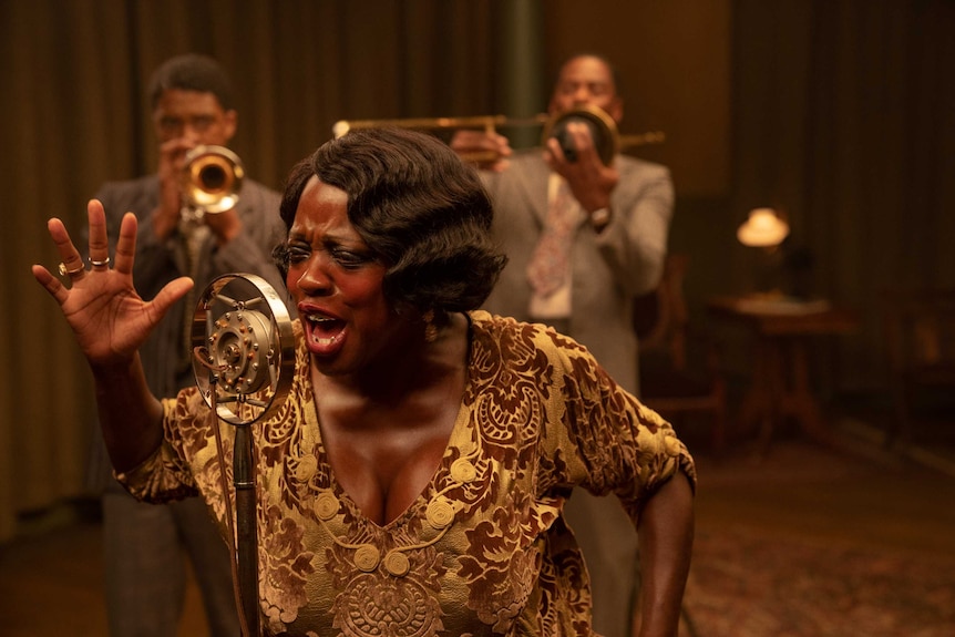 A scene from Ma Rainey's Black Bottom with Viola Davis singing passionately into a 1920s microphone
