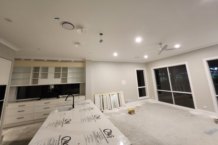 an unfinished kitchen in a partially built home with building supplies and materials around