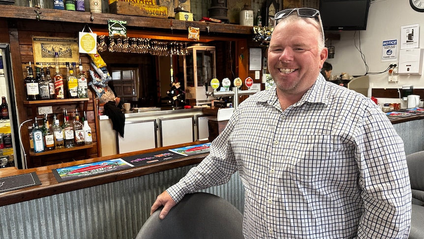 smiling middle aged man standing at a pub bar