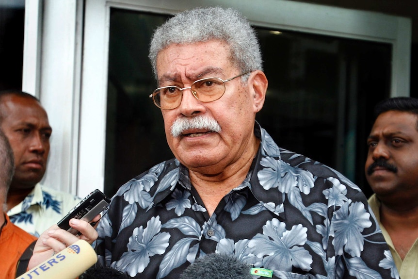 Fiji's former Prime Minister Laisenia Qarase talks to members of the media outside his office, December 2, 2006