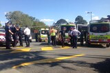 Police and paramedics discuss the stabbing at Beenleigh.
