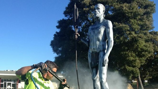 A council worker sprays the statue clean