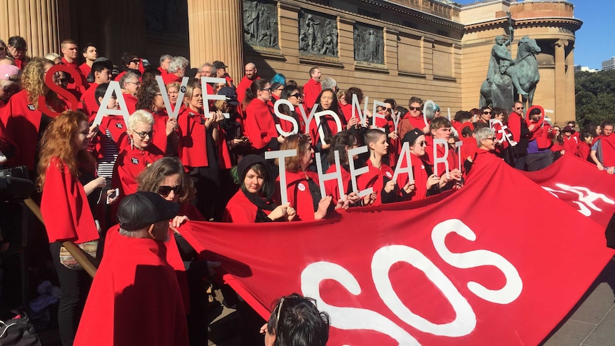 Group of young people holding up signs, letters, placards in front of Art Gallery of NSW.