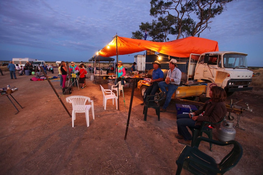 The group of professional drovers and tourist-drovers enjoy a camp oven dinner under the stars.