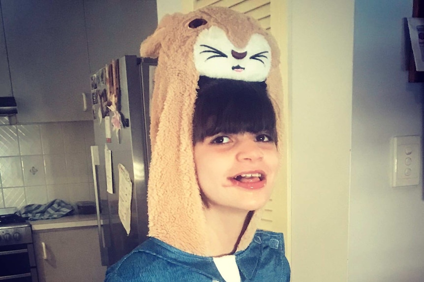 Lucy stands in the kitchen wearing a Peter Rabbit costume and smiling