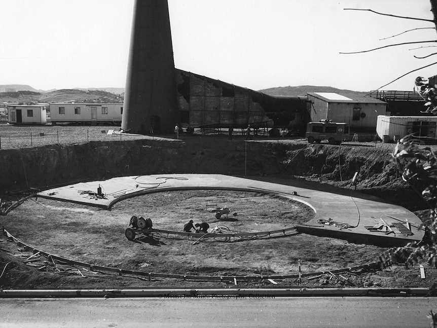 A large circular area of concrete being laid in the ground.
