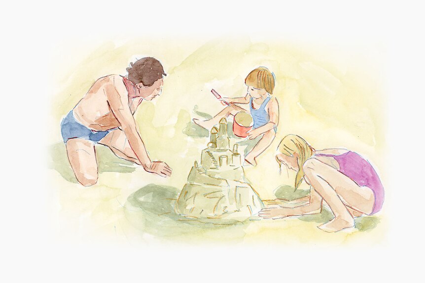 Father builds sandcastles on the beach with his two young daughters.