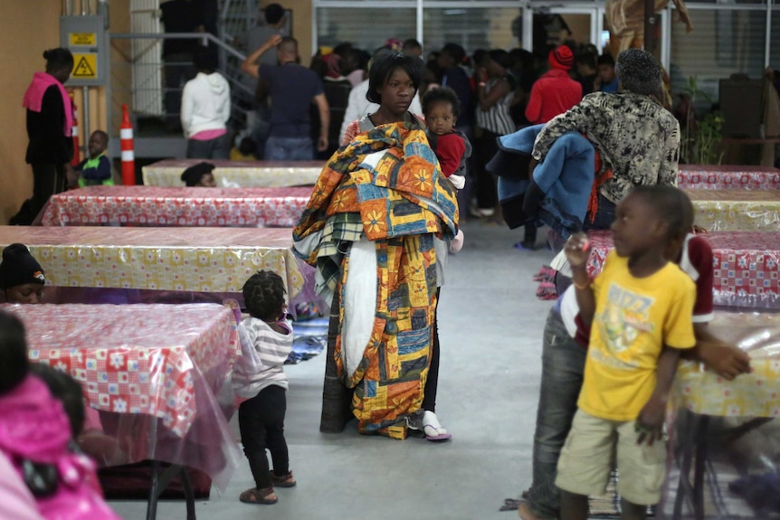 Haitian migrants carry blankets inside a shelter in Tijuana.