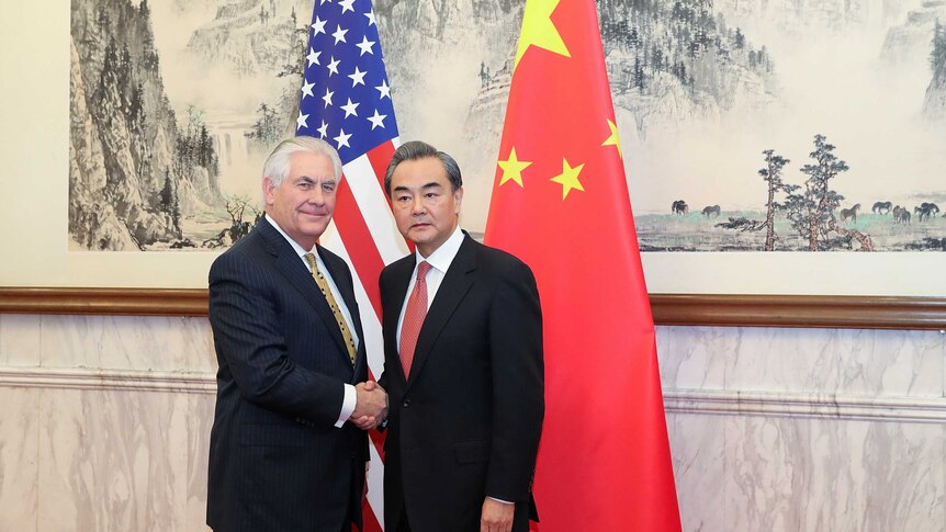 Rex Tillerson shakes hands with Chinese foreign minister Wang Yi (R)