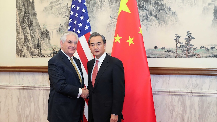 Rex Tillerson shakes hands with Chinese foreign minister Wang Yi (R)