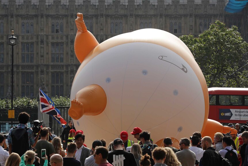 The Trump Baby balloon lays on its back. It is depicted wearing a diaper.