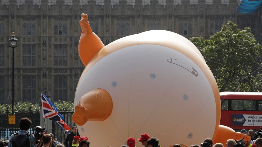 The Trump Baby balloon lays on its back. It is depicted wearing a diaper.