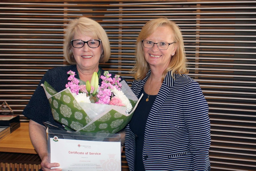 Christine Jones receives her 50 years of service award from Professor Shirley Bowen.
