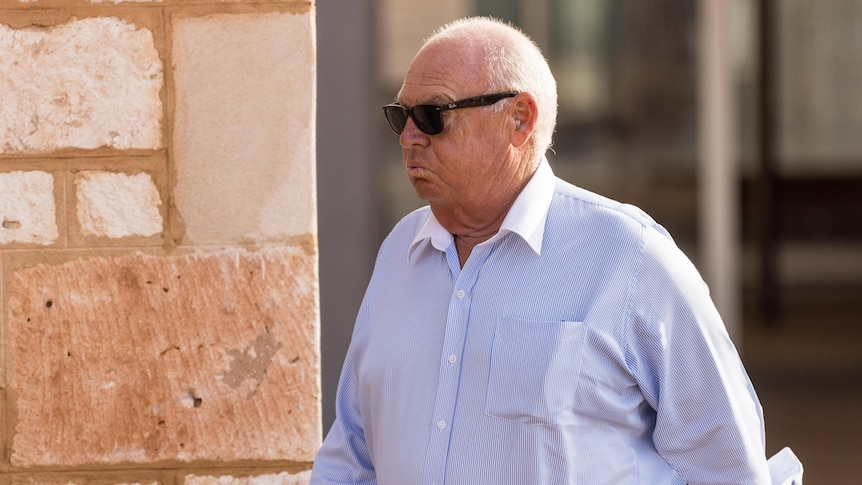 A man walking outside of courthouse after trial.  