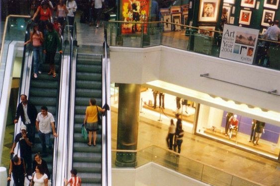 Shoppers on an escalator in a shopping mall