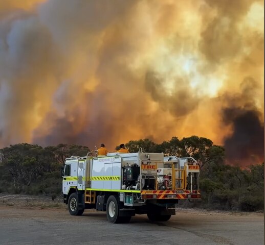 firefighters inside  truck in front of a fire at greenrtange in western australia