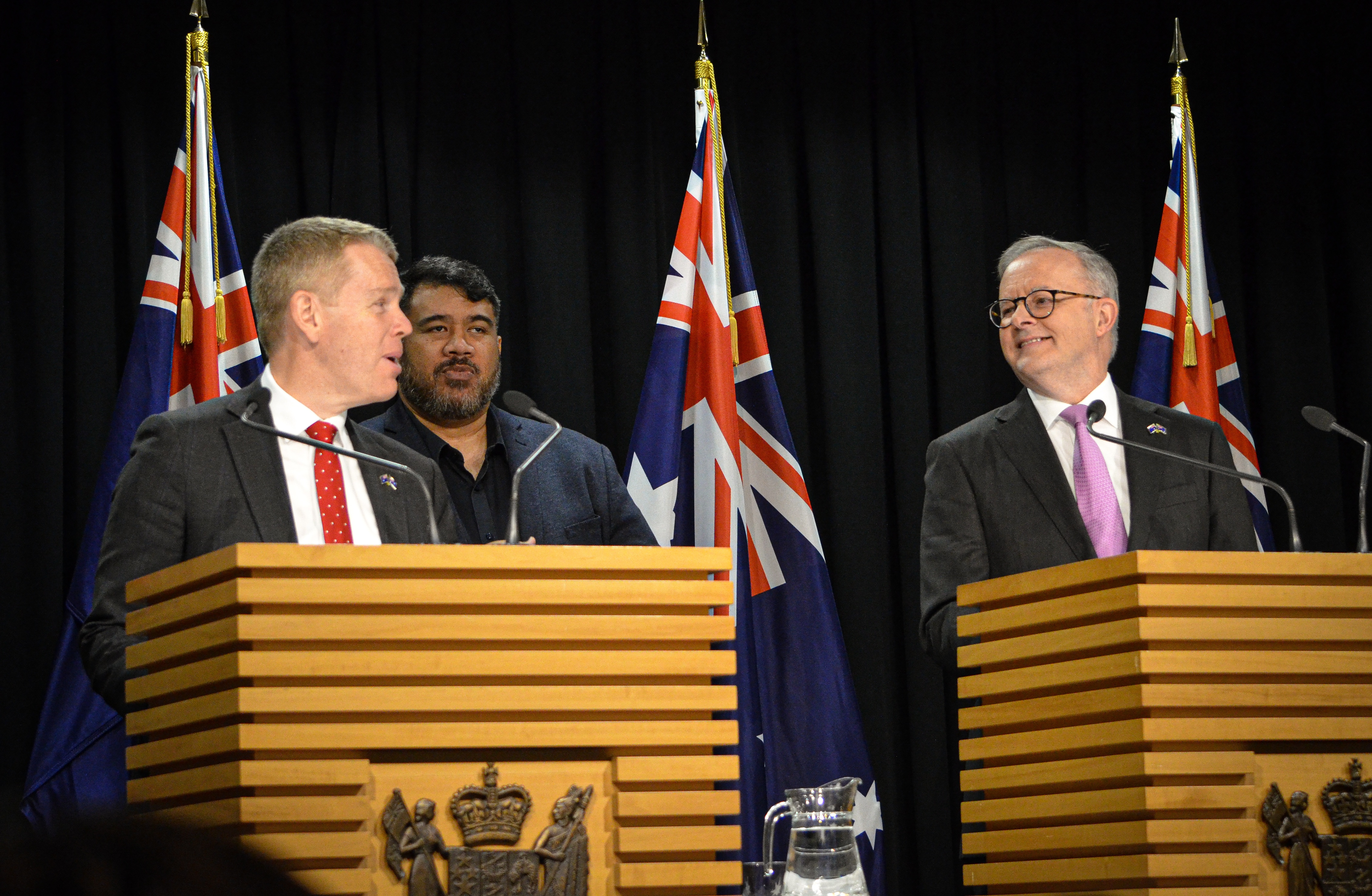 Chris Hipkins and Anthony Albanese standing at podiums at a press conference. 