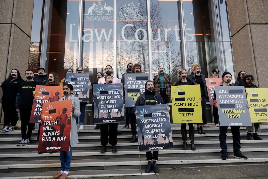 Protesters holding signs outside of a court.