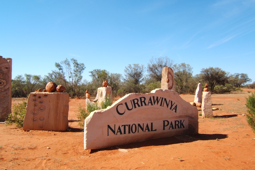 Currawinya National Park entry sculpture made of stones sits among other smaller sculpture red soil.