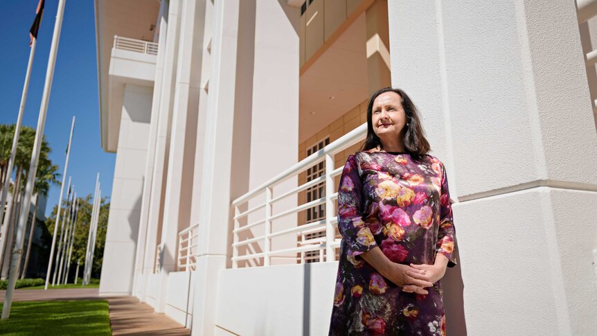 A photo of NT politicians Robyn Lambley leaning against a column of NT Parliament and looking into the distance.