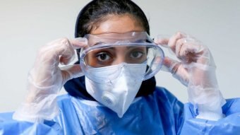 A woman wears PPE.