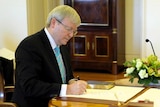 Kevin Rudd signs his commission as Prime Minister at Government House after leadership win.