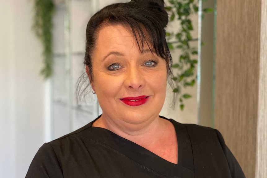 A head and shoulders photo of a beauty studio owner in a black top.