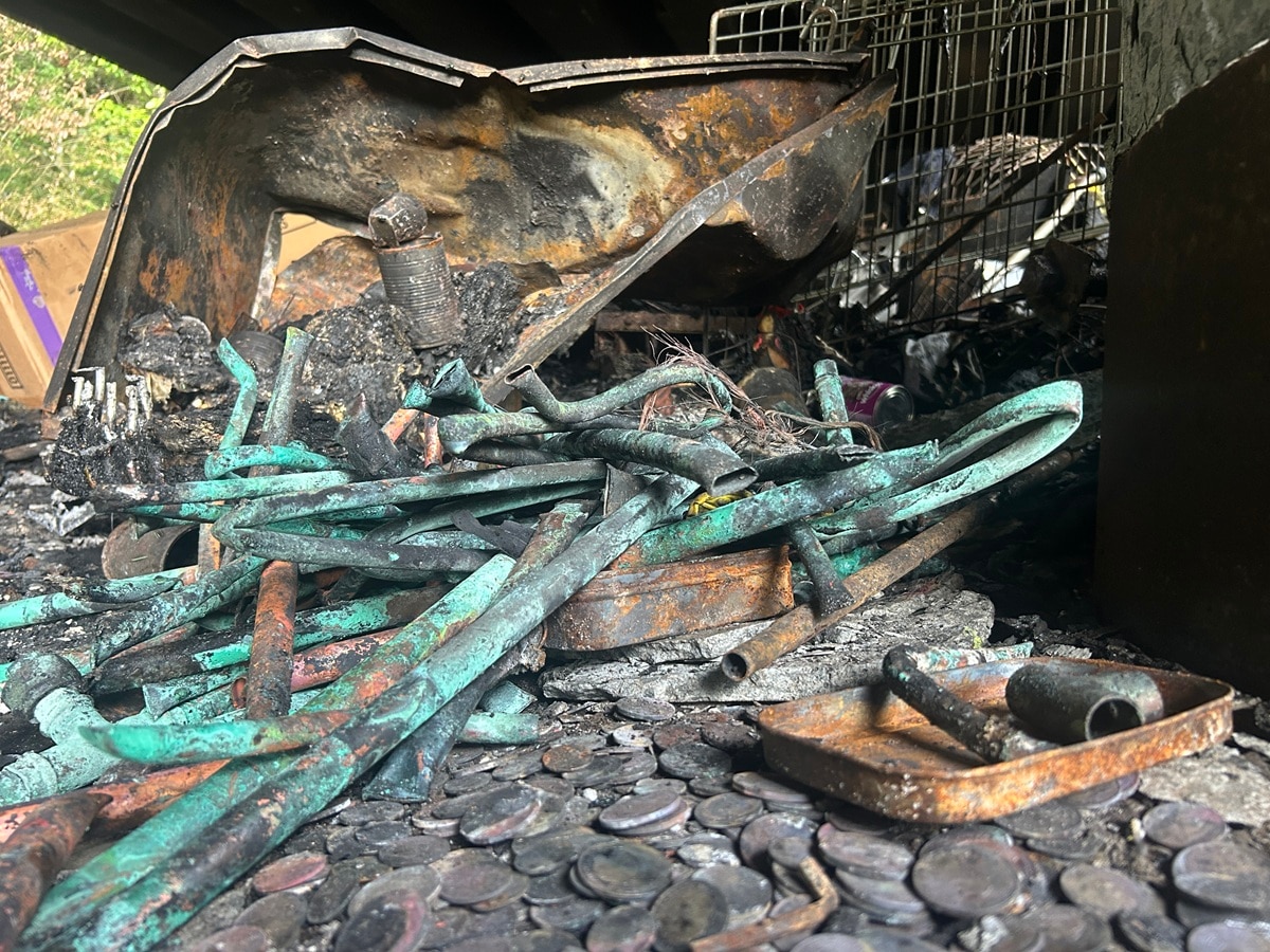 Cobre quemado y monedas en un montón de cenizas.