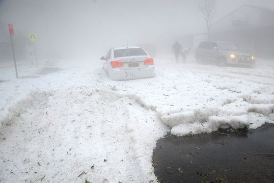 A car in a misty snow and hail storm