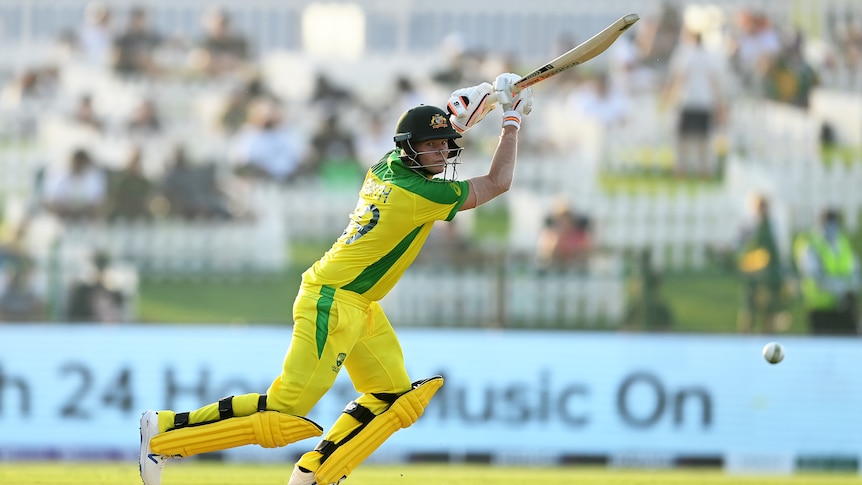 An Australian batsman watches the ball fly away after playing a shot on the off-side in a T20 World Cup game.