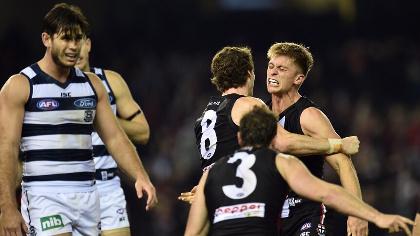 St Kilda players (R) react to their win over Geelong, next to the Cats' Tom Hawkins (L).