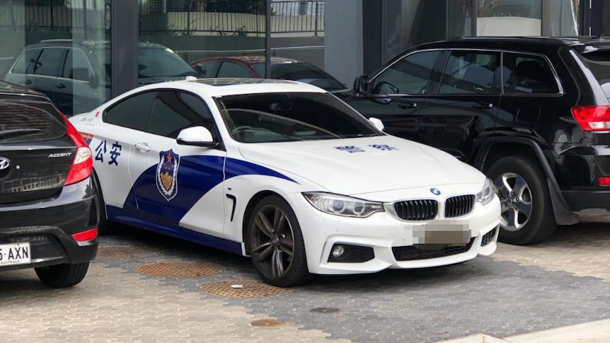 A car with what appears to be Chinese police markings parked at night.