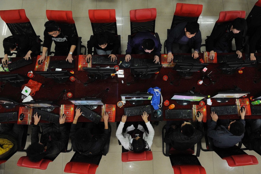 People use the computer at an Internet cafe.