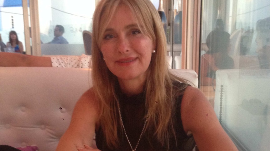 A portrait of Sandra Rokebrand shows her sitting at a table with her arms crossed.