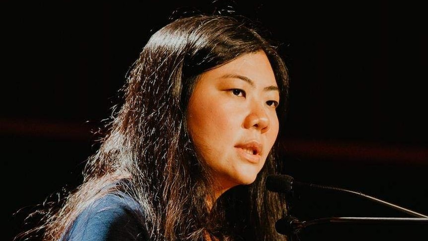 Human rights lawyer Veronica Koman talks behind a podium.