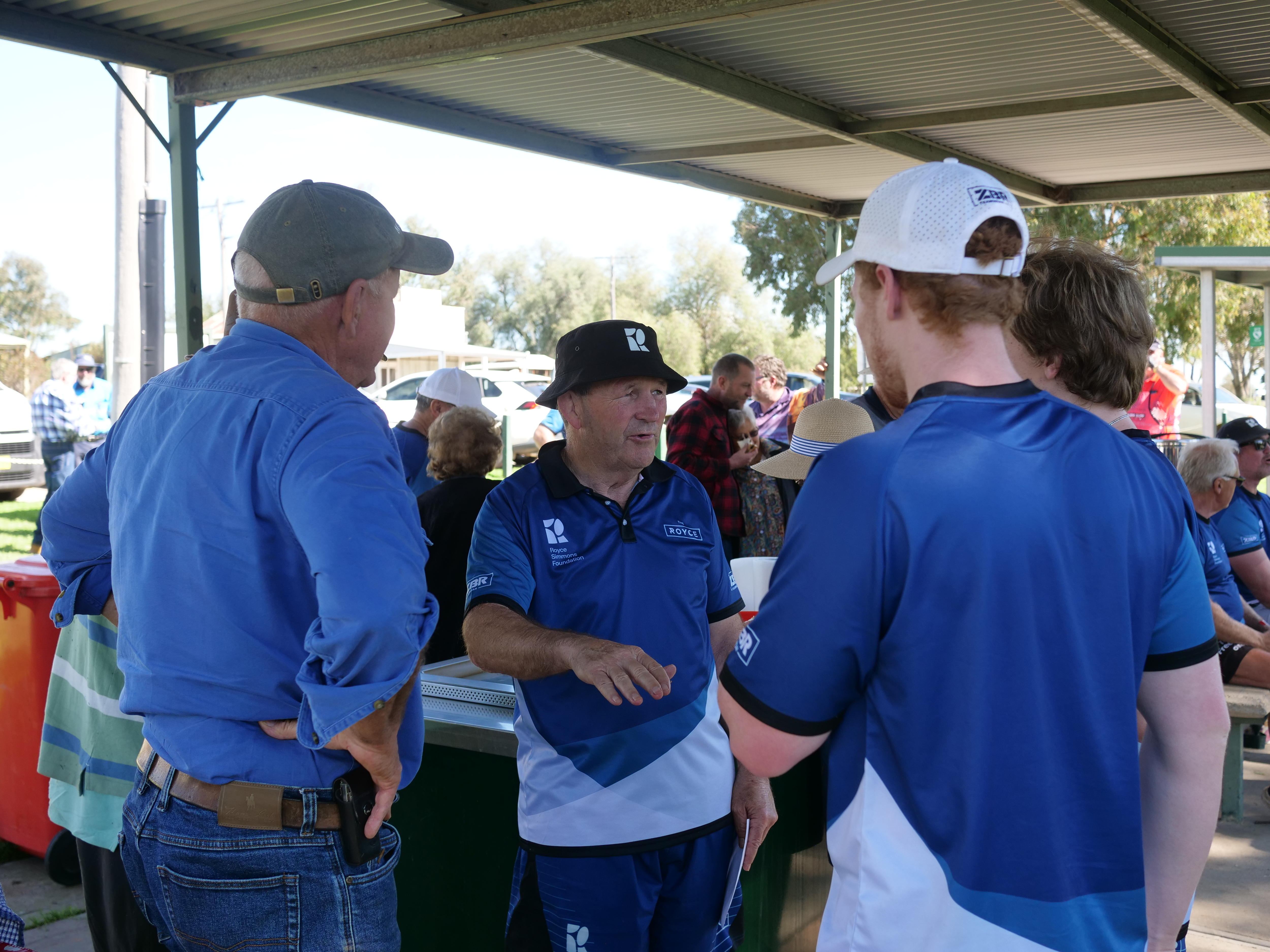 Royce Simmons talking with 3 other men