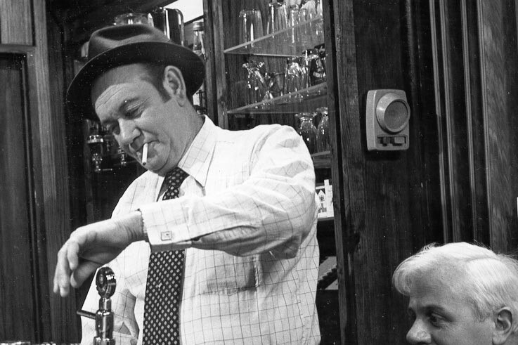 A black and white photo of a man in a pub