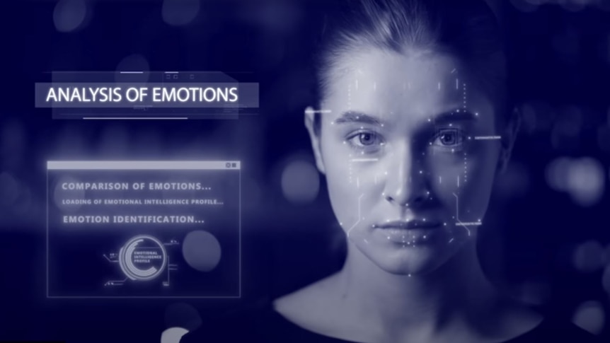 In a still from a video, a woman's face is scanned while the words "analysis of emotions" are shown.