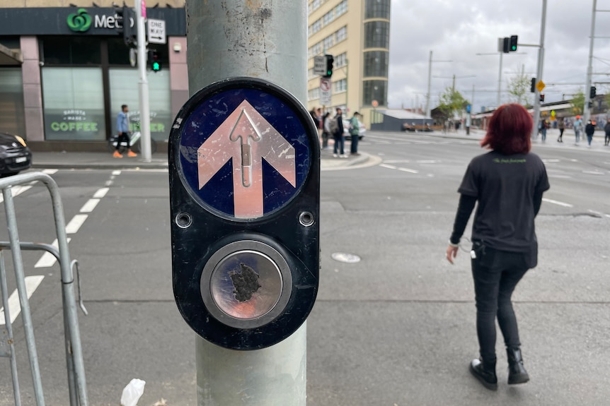 A pedestrian crossing button at an intersection